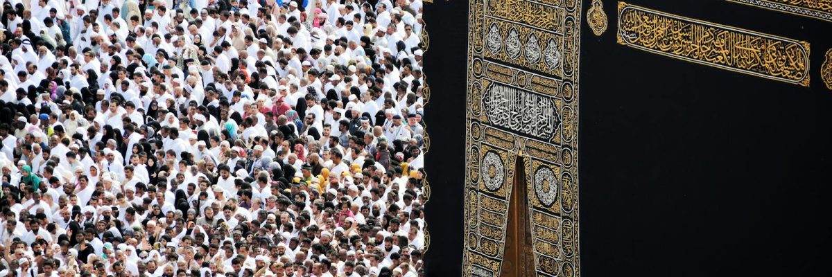 Mass of pilgrims in traditional attire at Kaaba during the Hajj pilgrimage.